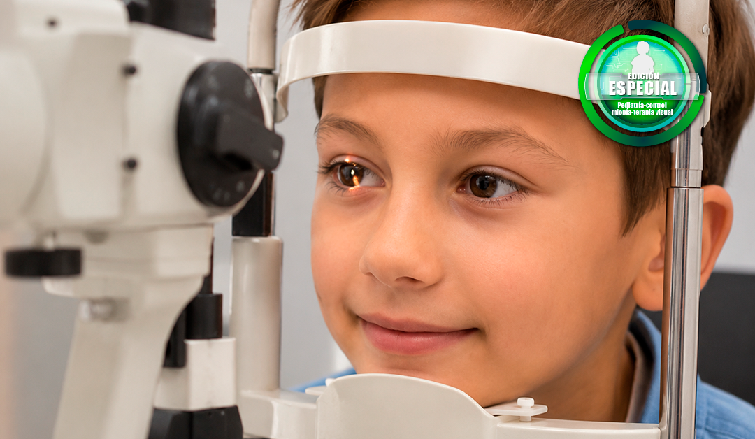 Close-up of a young boy undergoing an eye exam with a slit lamp, wearing a headband and looking to the side, with a logo badge in the top-right corner.