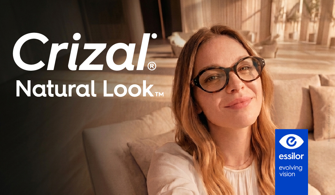 Woman wearing black-framed glasses sits on a sofa, smiling; Crizal Natural Look ad with Essilor logo.