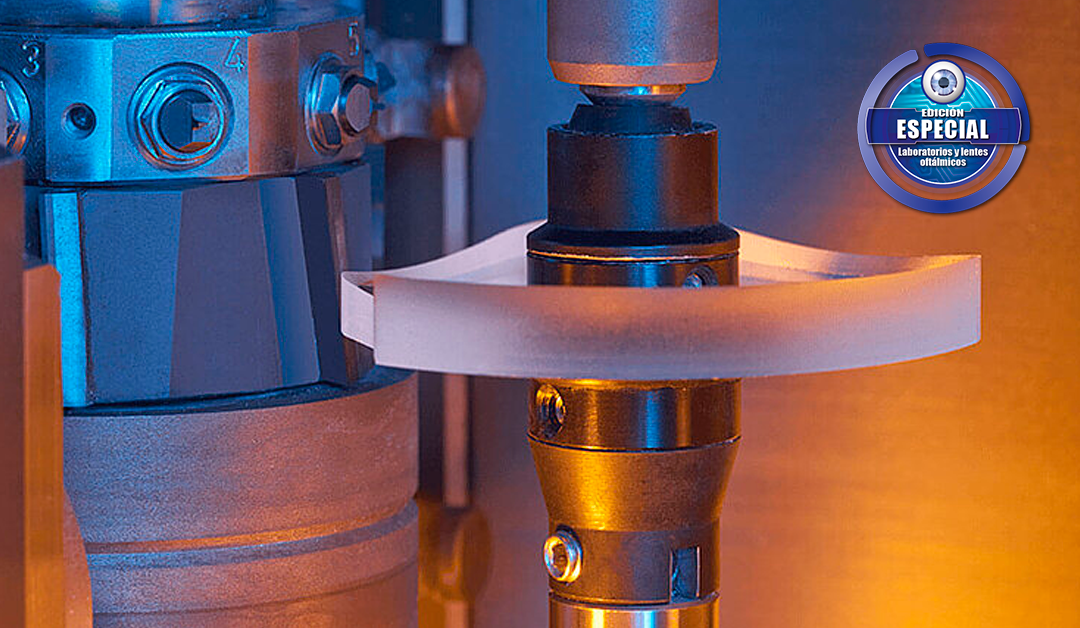 Close-up of a lens-polishing machine with a white curved polishing belt around a gold rotary shaft under blue and orange lighting.