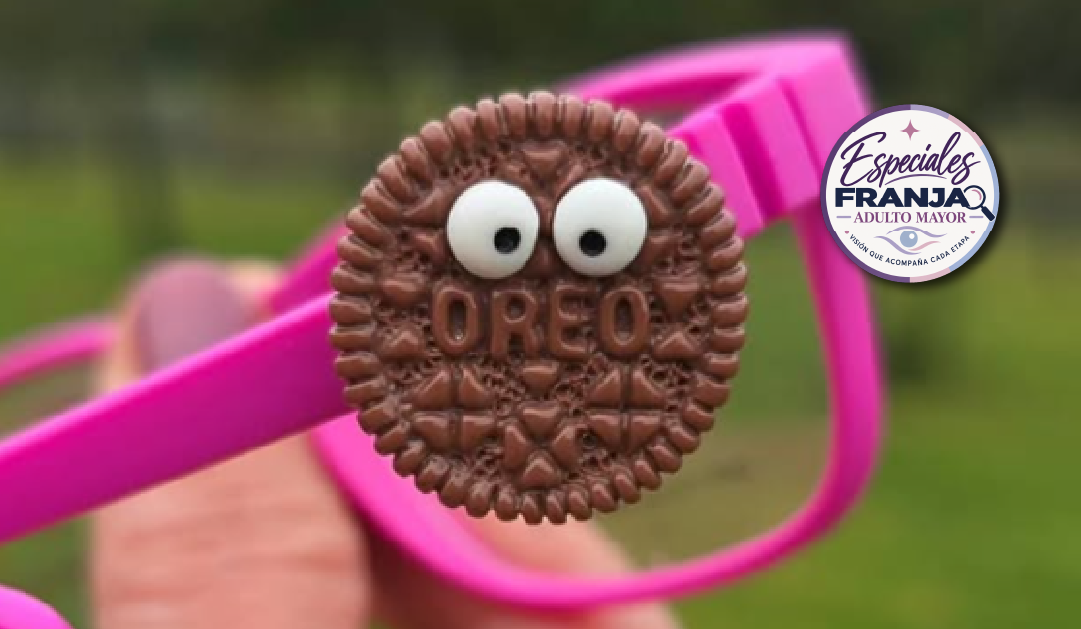 Oreo cookie with googly eyes and the word 'OREO' visible, perched on a pink glasses strap outdoors with a branding badge in the corner.